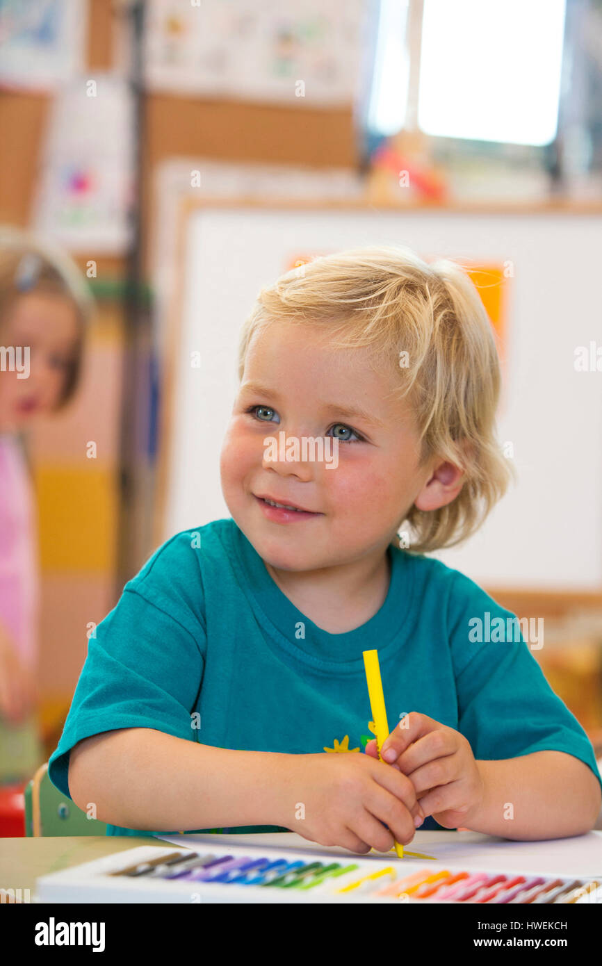 Vorschule junge mit Färbung Stift im Klassenzimmer Stockfoto
