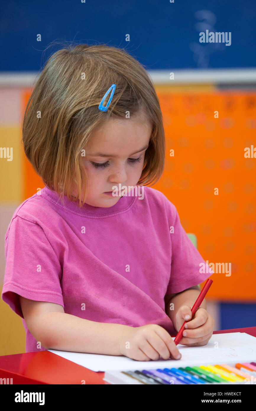 Kindergarten Mädchen mit Färbung Stift im Klassenzimmer Stockfoto