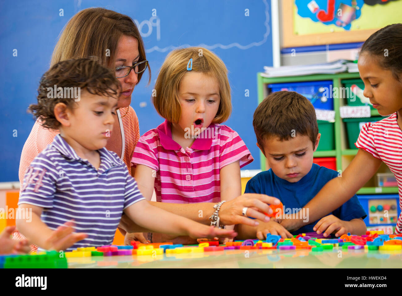 Lehrerin mit Vorschule jungen und Mädchen lernen Alphabet im Klassenzimmer Stockfoto