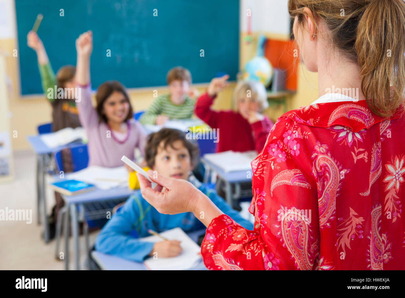 Über die Schulter-Blick der Grundschullehrerin, die Befragung im Klassenzimmer Stockfoto