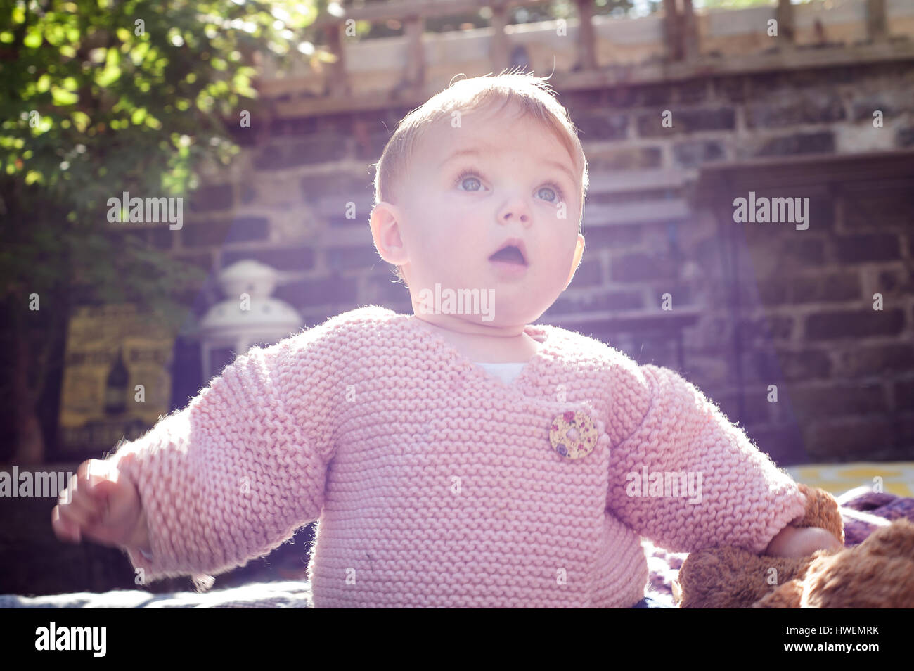 Überrascht Babymädchen mit offenem Mund im Garten Stockfoto