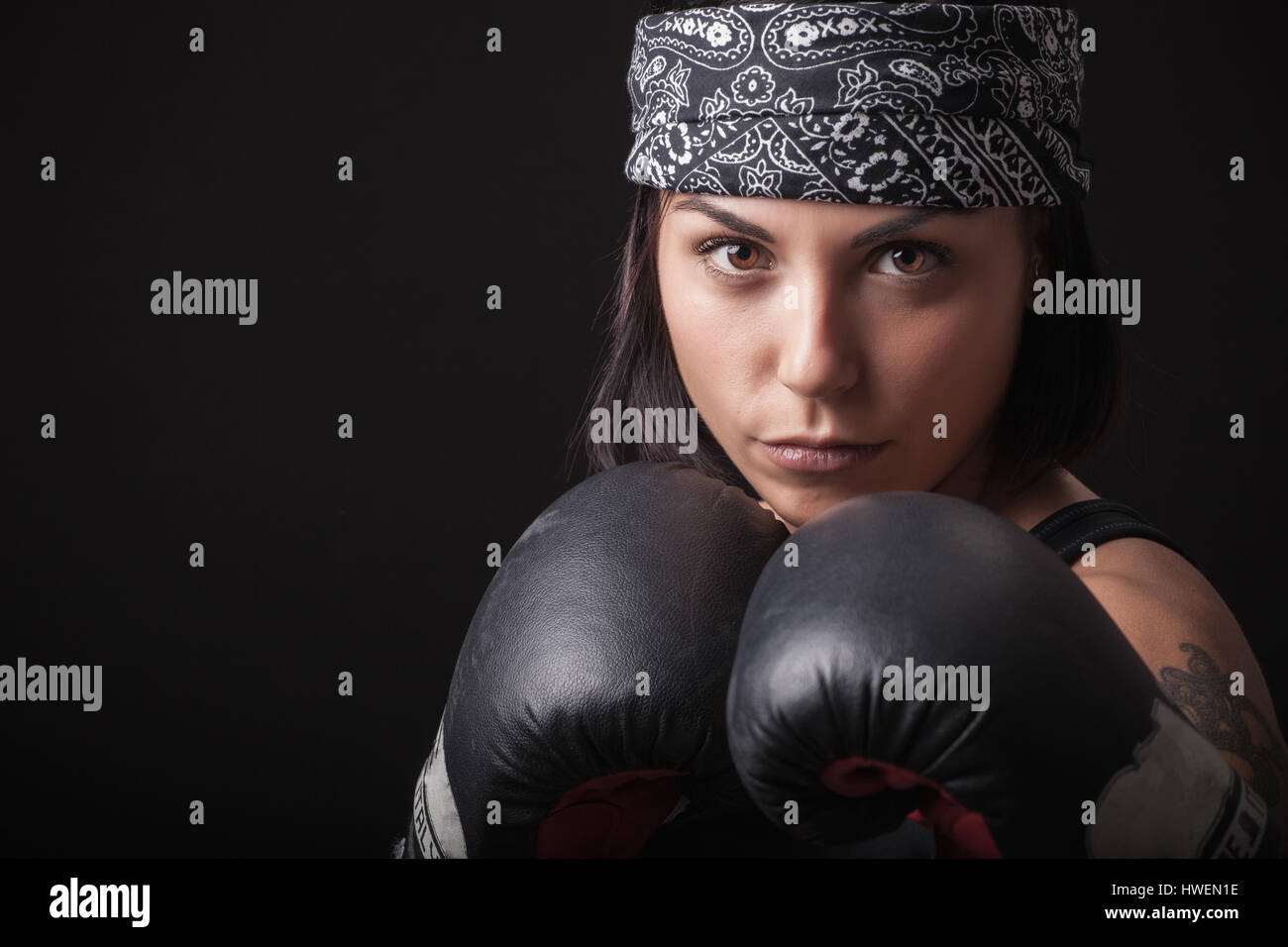 Porträt der jungen Frau mit Boxhandschuhen, bei der Bekämpfung der Haltung Stockfoto