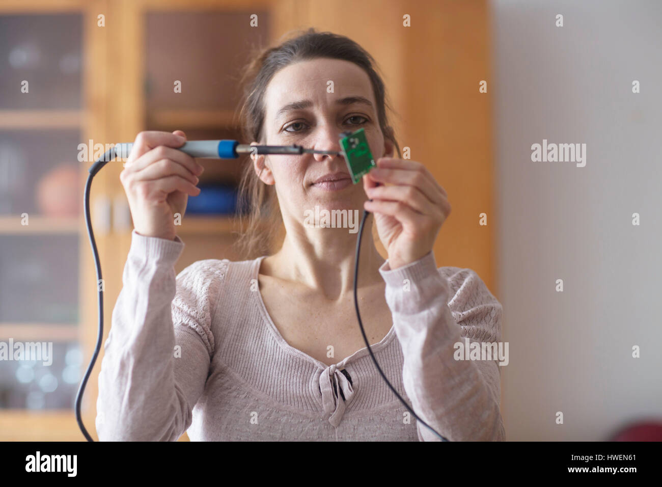 Frau mit Lötkolben Stockfoto