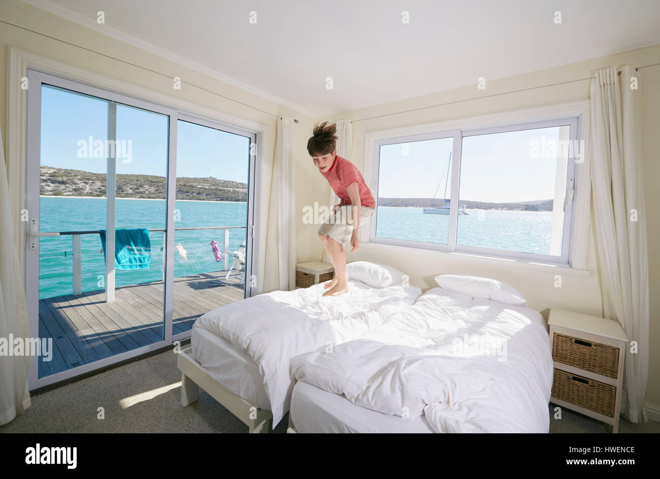 Junge, springen auf Bett im Hausboot, Kraalbaai, Südafrika Stockfoto