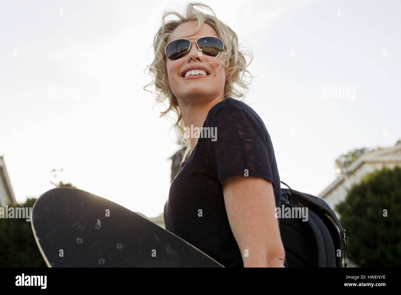 Weibliche Skater tragen Skateboard im park Stockfoto