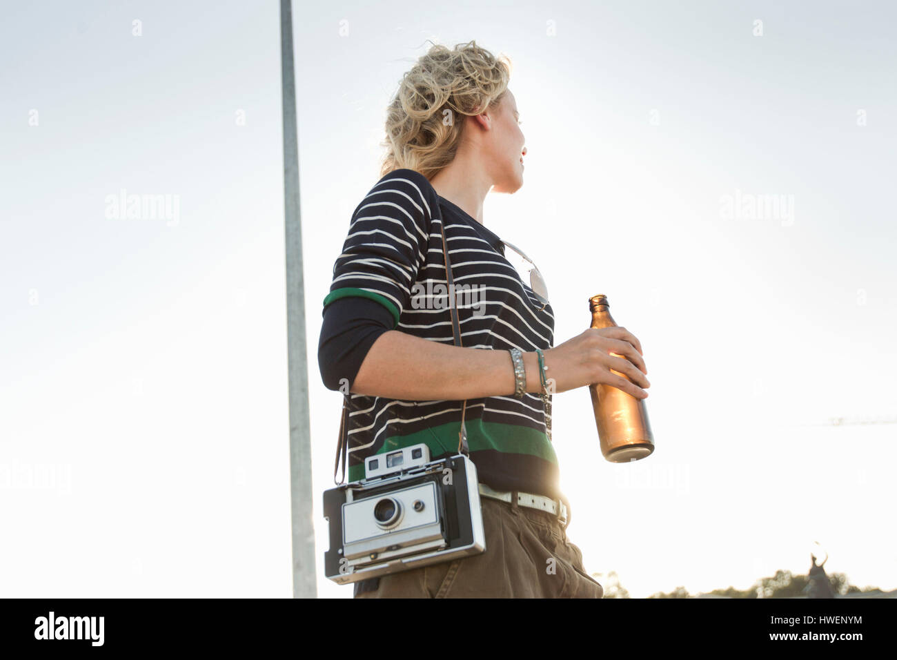 Mitte Erwachsene Frau, die Bierflasche und Vintage-Kamera im park Stockfoto