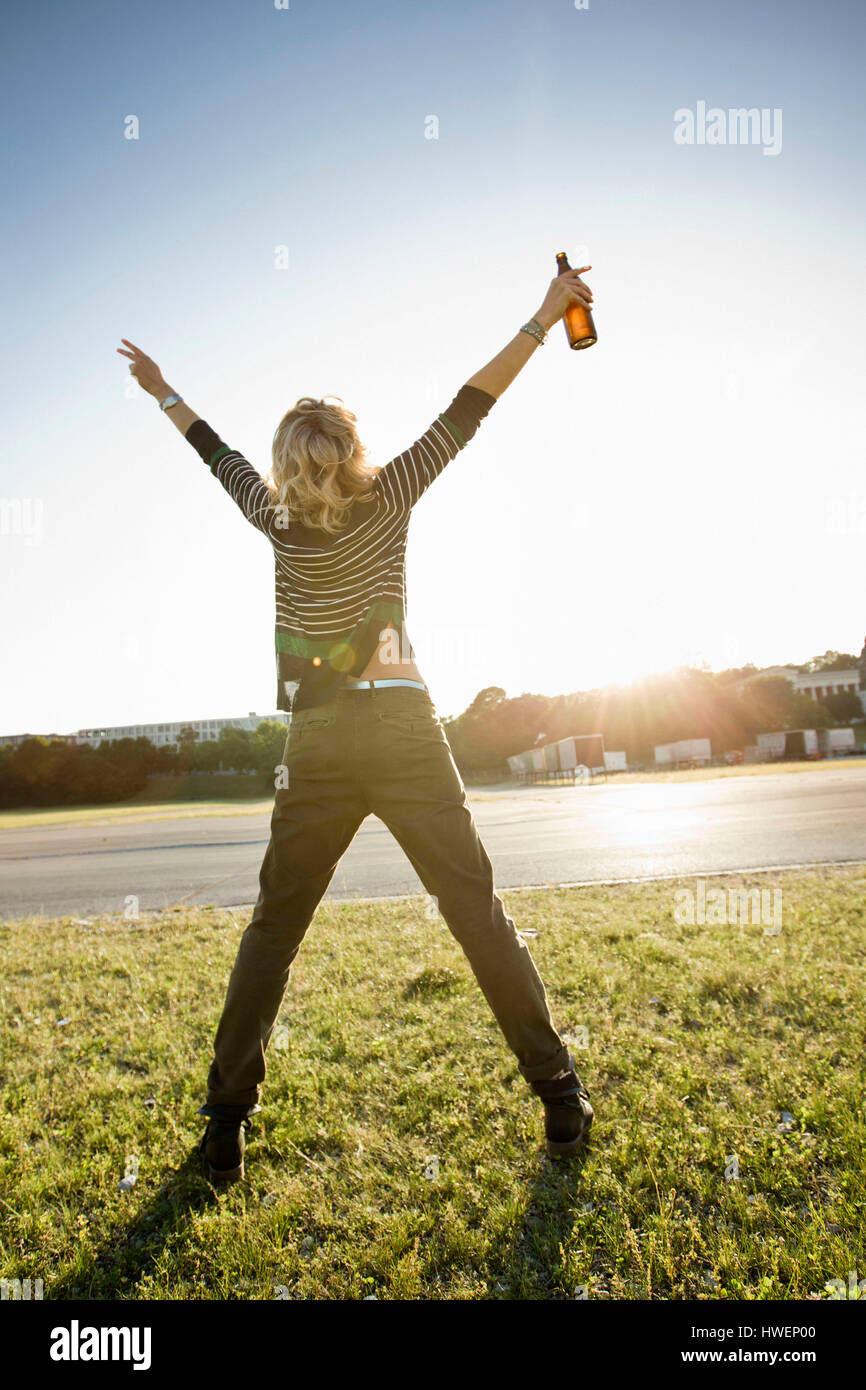 Rückansicht des Mitte Erwachsene Frau im Park mit offenen Armen Stockfoto