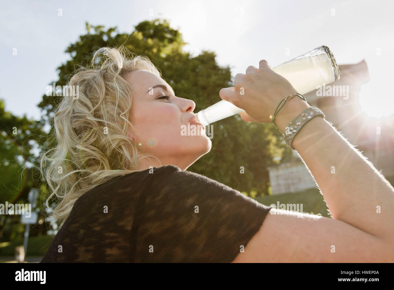 Mitte Erwachsene Frau im sonnigen Park trinken Limonade Stockfoto