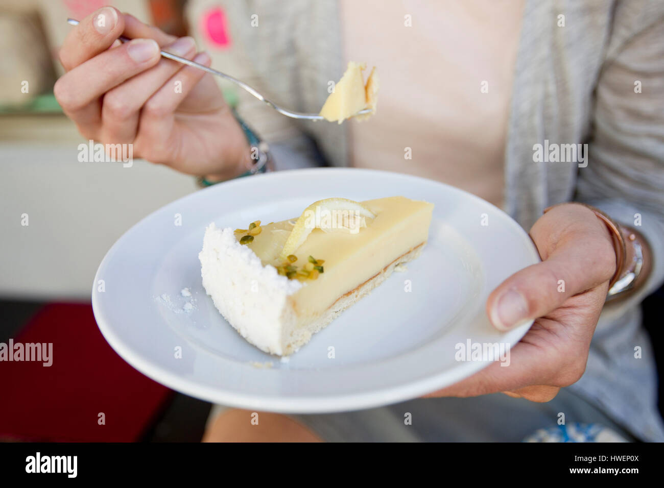 Mittleren Bereich der Frau essen Kuchen in Stadt Straßencafé Stockfoto