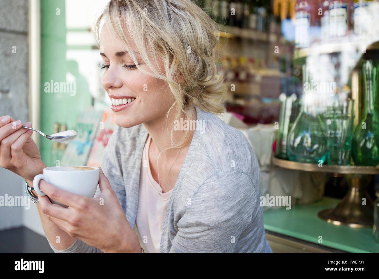 Mitte Erwachsene Frau Schaum aus Kaffeetasse in Stadt Straßencafé Essen Stockfoto