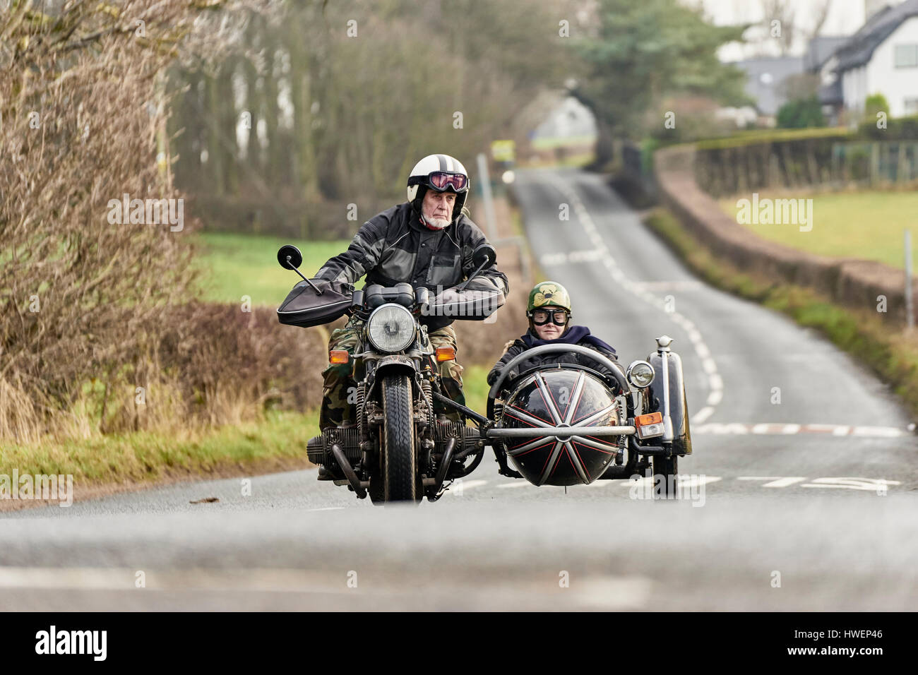 Ältere Mann und Enkel fahren Motorrad und Beiwagen auf Landstraße Stockfoto