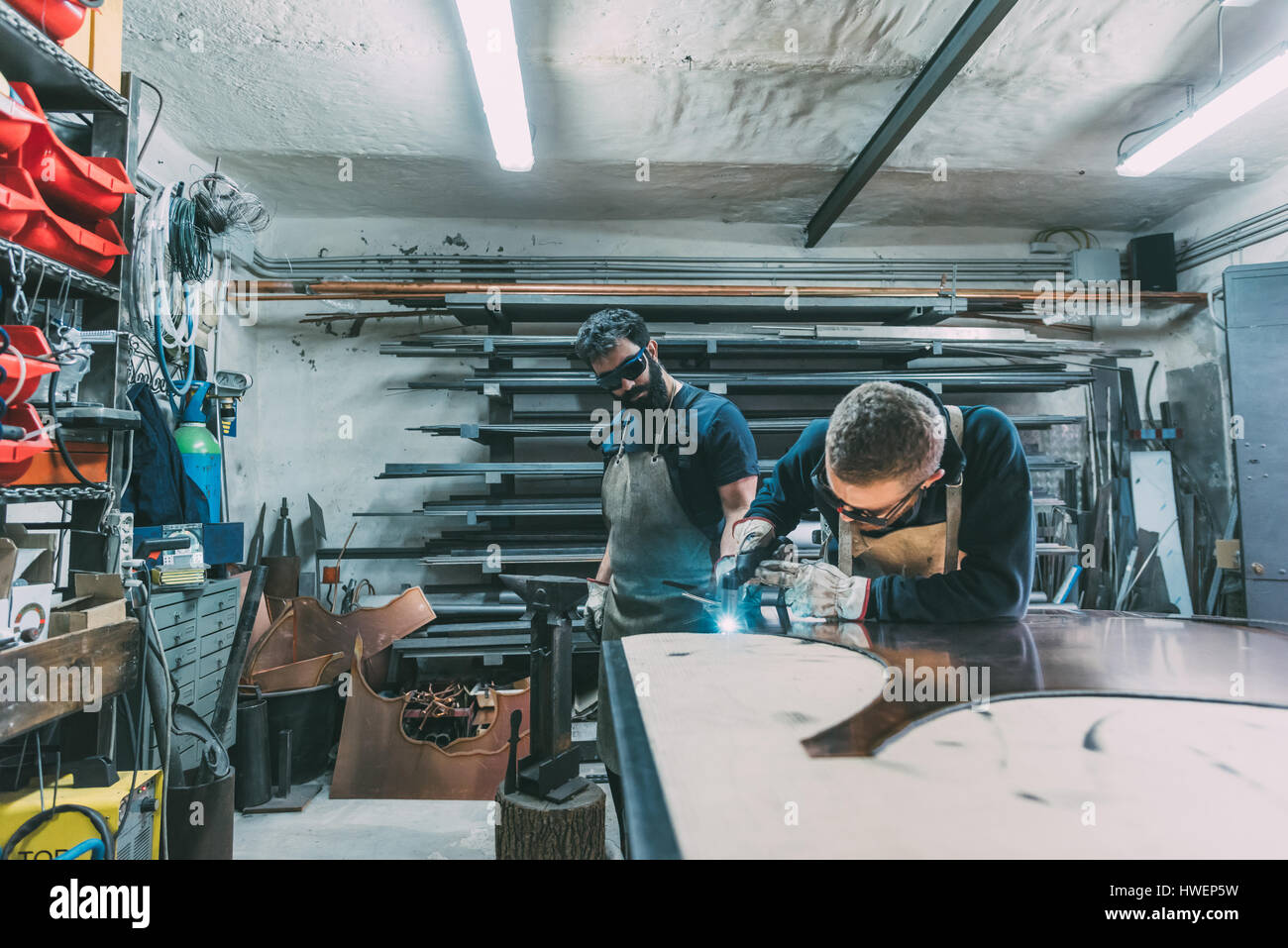 Schlosser schneiden Kupfer mit Schweißbrenner in Schmiede-Werkstatt Stockfoto
