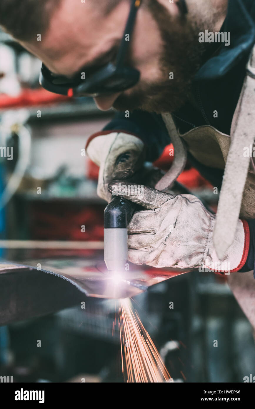 Schlosser schneiden Kupfer mit Schweißbrenner in Schmiede-Werkstatt Stockfoto