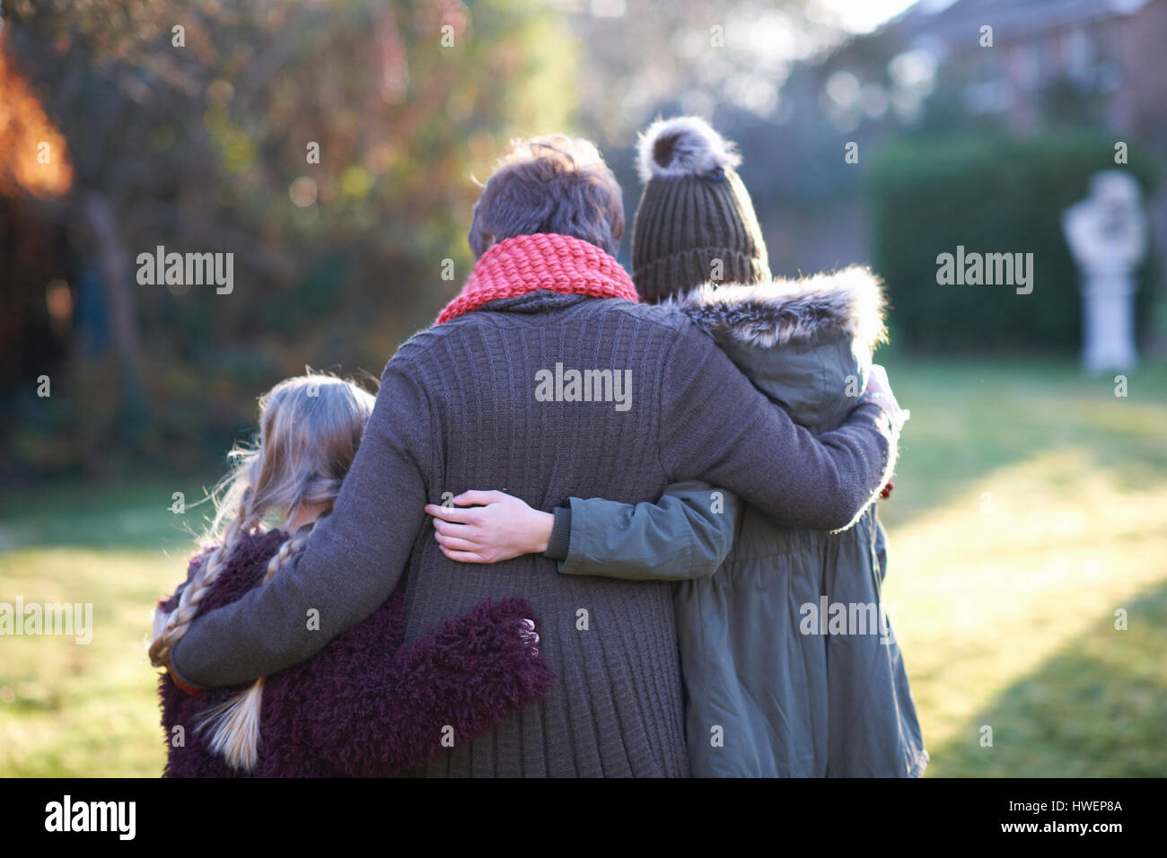 Großmutter und Enkelinnen umarmt im Garten Stockfoto