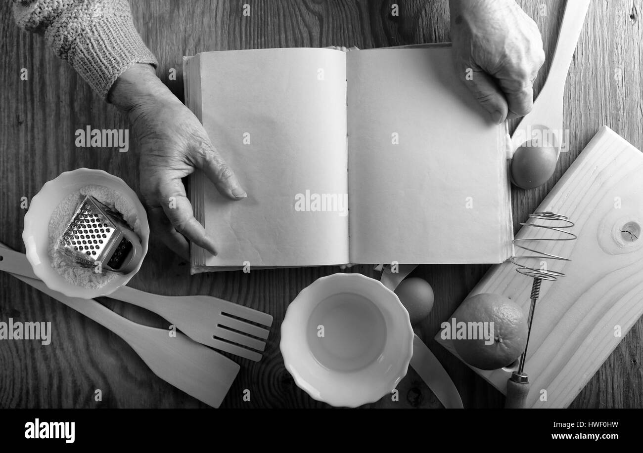 Rezept-Buch in den Händen einer älteren Frau Stockfoto