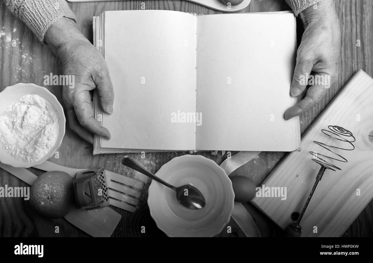 Rezept-Buch in den Händen einer älteren Frau Stockfoto