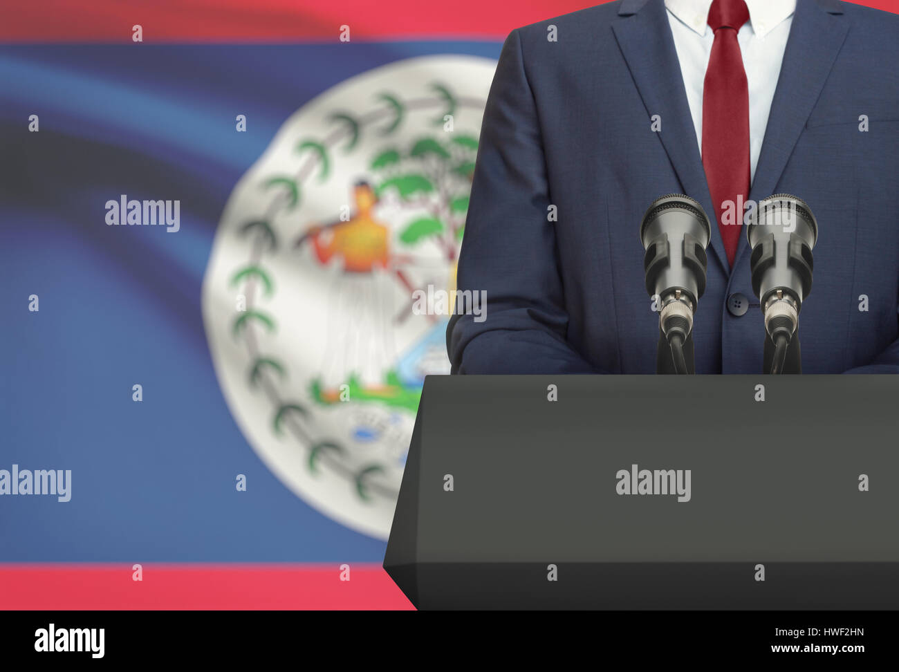 Geschäftsmann oder Politiker Redebeitrag hinter der Kanzel mit Nationalflagge auf Hintergrund - Belize Stockfoto