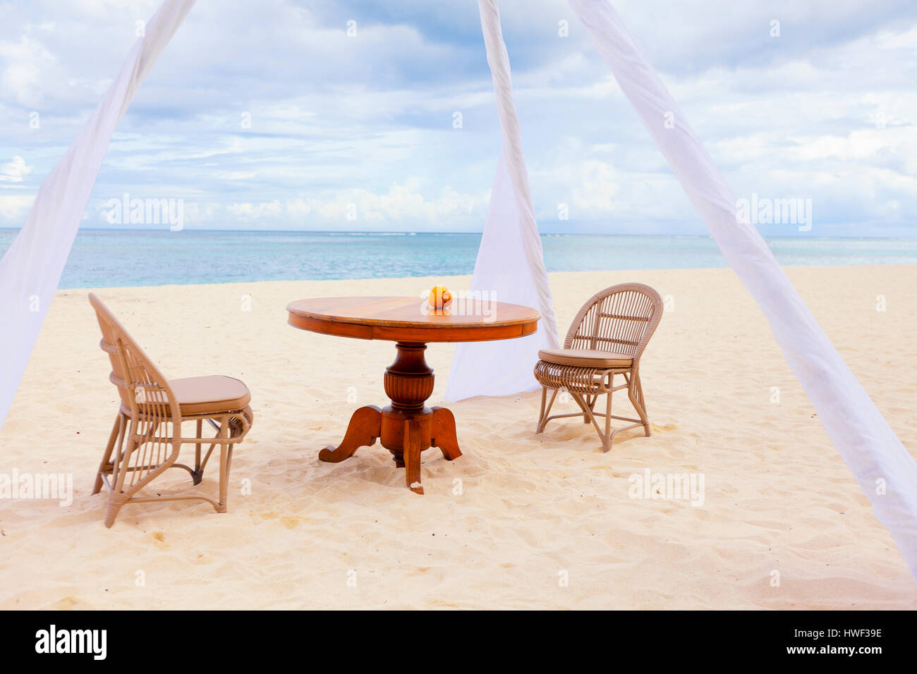 Private Dining Table und Strandkörben für romantisches Abendessen für Paare auf Hochzeitsreise auf einem tropischen Strand Stockfoto