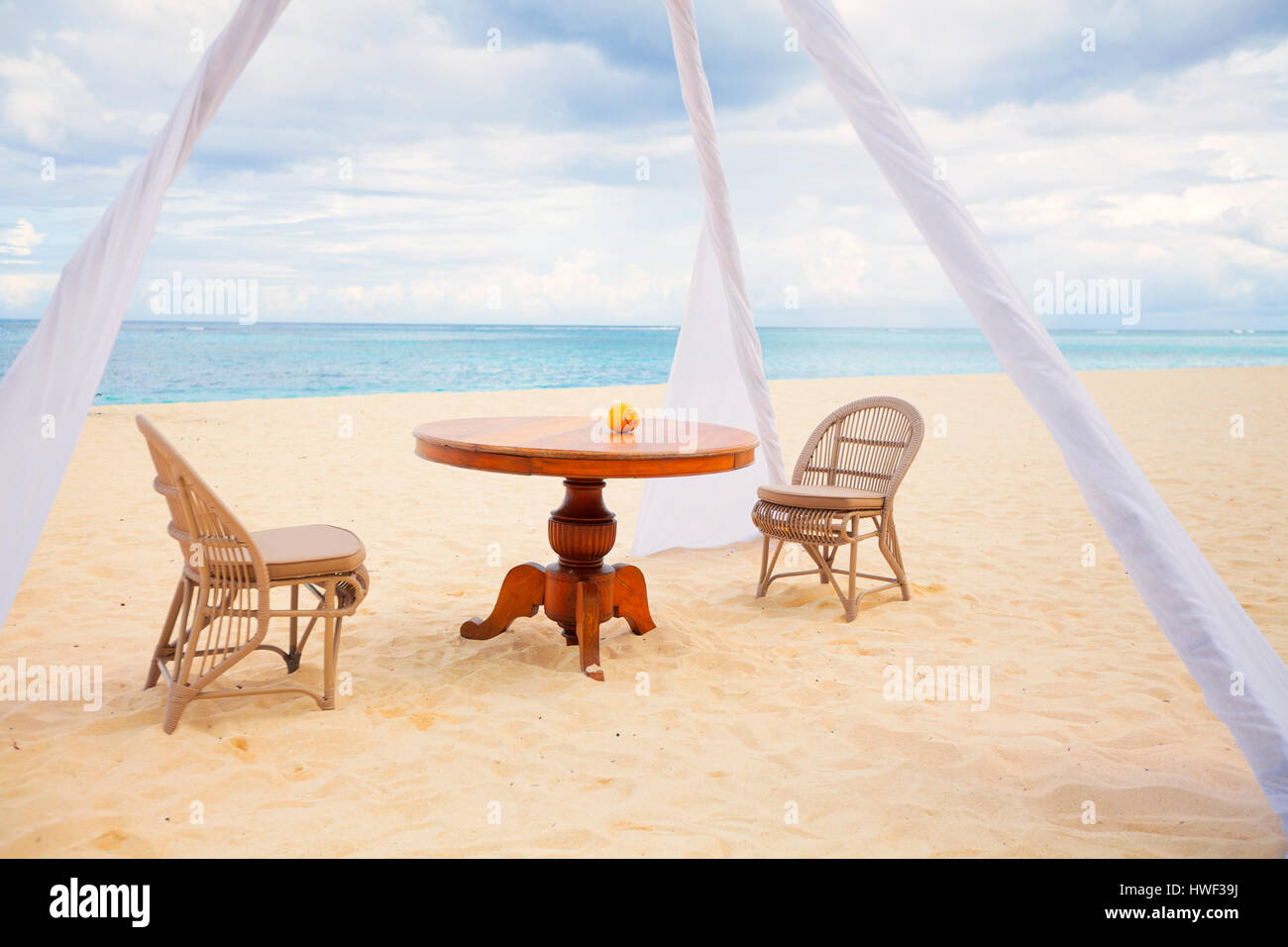 Private Dining Table und Strandkörben für romantisches Abendessen für Paare auf Hochzeitsreise auf einem tropischen Strand Stockfoto