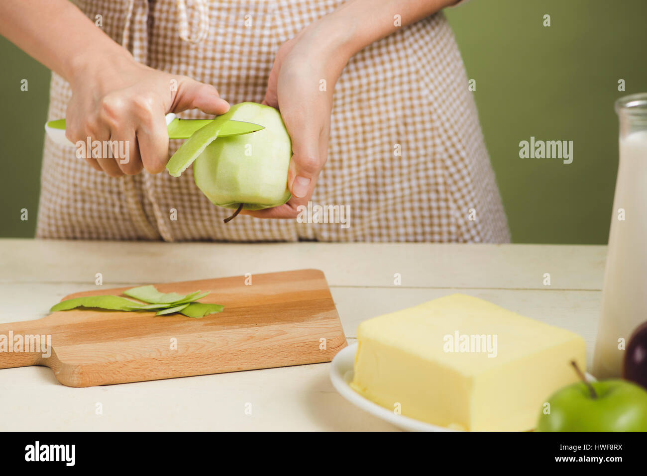 Haus Frau trägt Schürze machen. Schritte der Herstellung Kochen Apfelkuchen. Grünen Apfel schneiden. Stockfoto