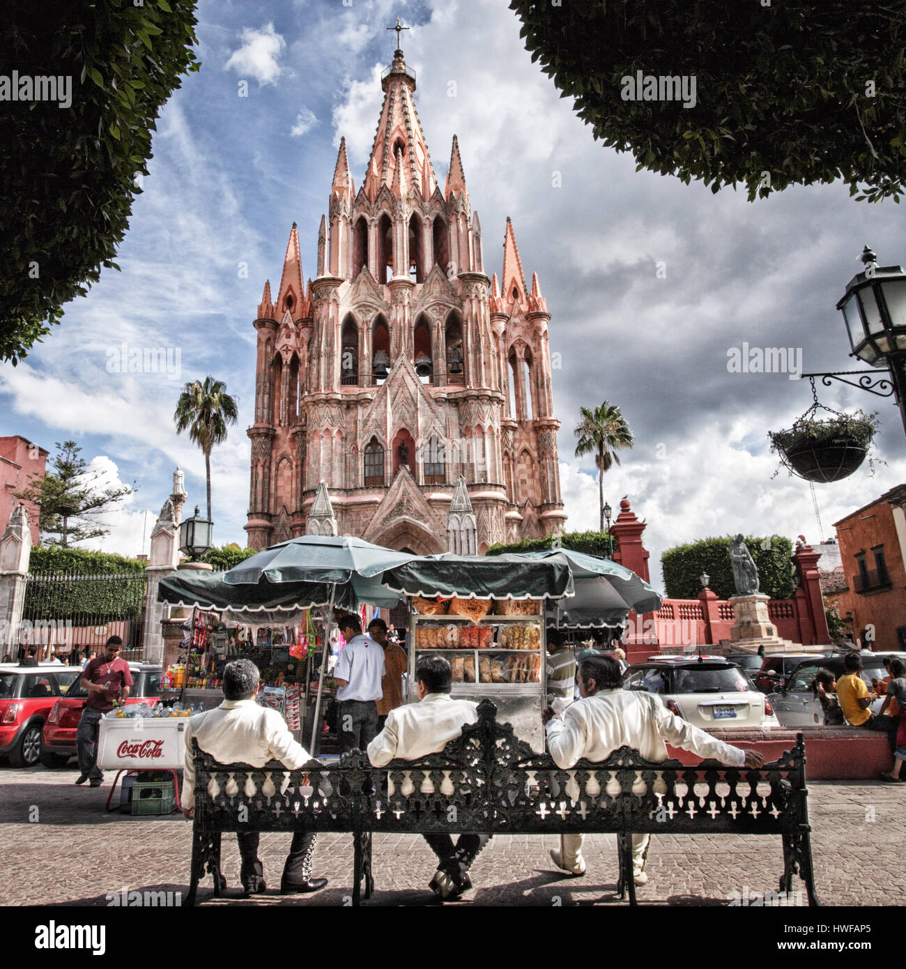Drei Spieler der Mariachi entspannen Sie auf einer Bank in der Nähe der Basilika in San Miguel de Allende, Mexiko. Stockfoto
