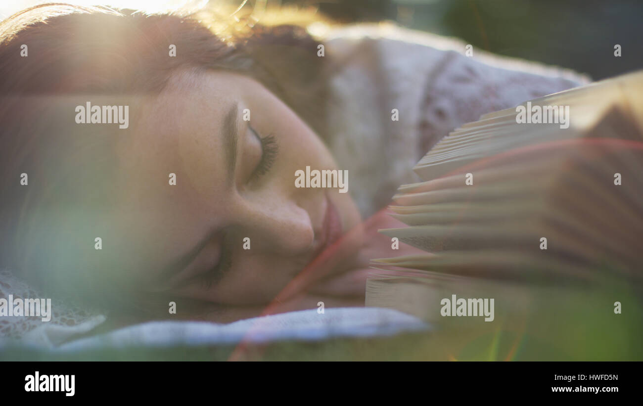 Nahaufnahme der selektiven Fokus der schlafenden Frau Verlegung im Park Rasen Nickerchen und Buch Stockfoto