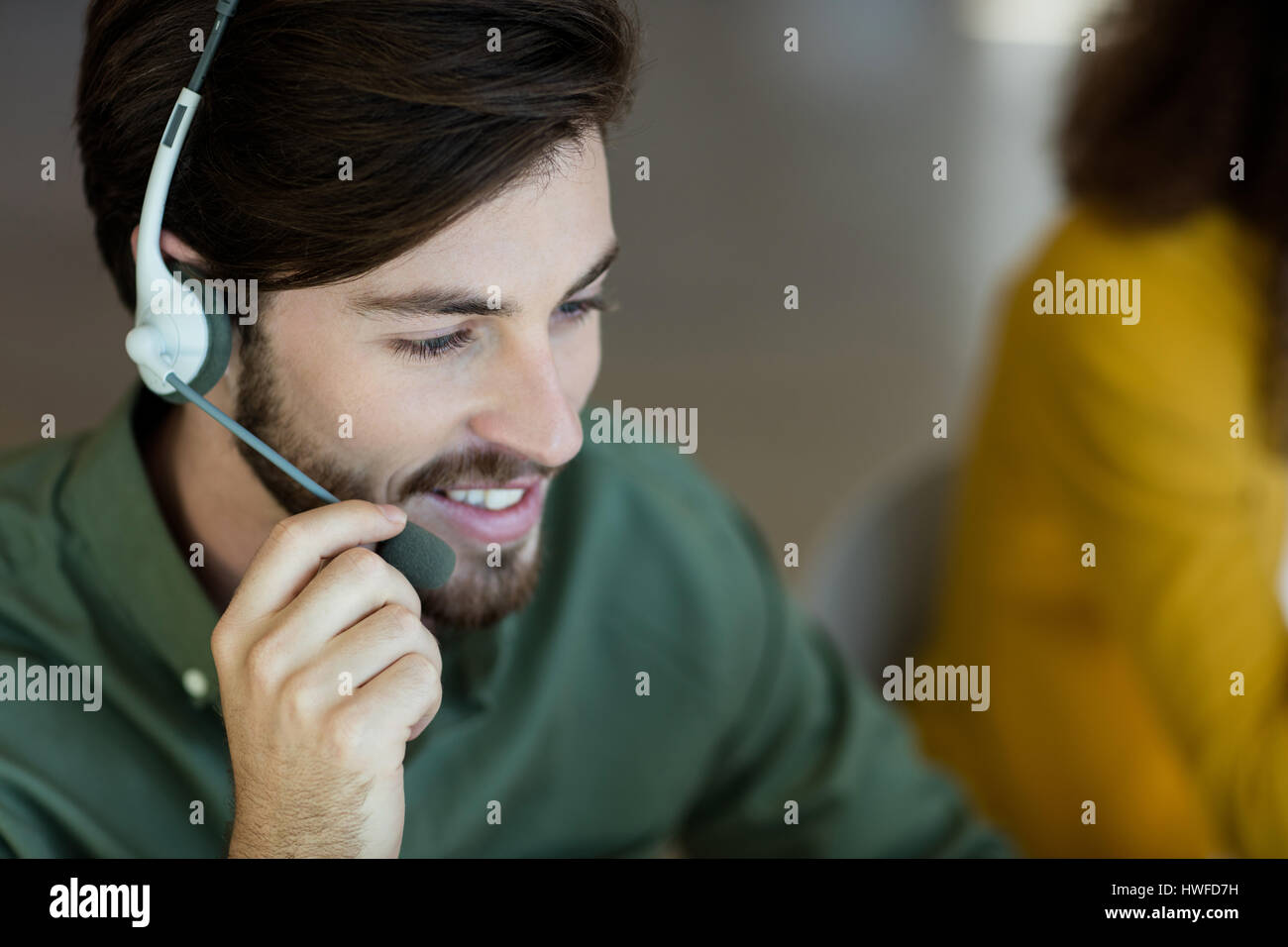 Lächelnde Kunden Service Executive am Kopfhörer im Büro sprechen Stockfoto