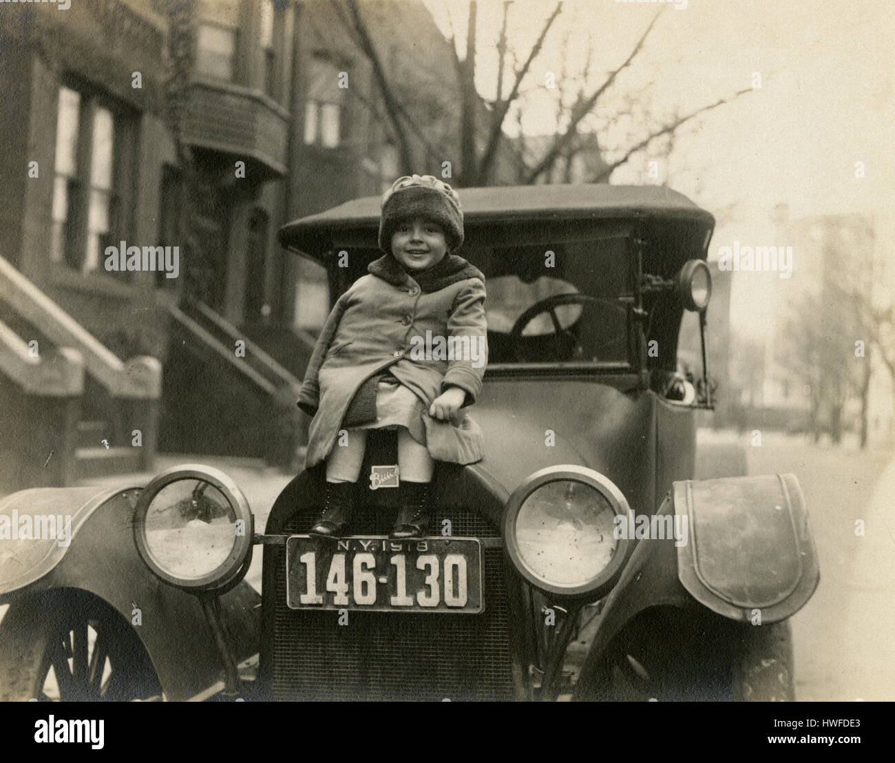 Antike c1918 Foto, kleines Mädchen auf der Motorhaube ein 1918 Buick mit New York-Kfz-Kennzeichen. Lage ist möglicherweise Brooklyn, New York. Alamy HWFDD1 für eine Alternative Ansicht des Bildes zu sehen. QUELLE: ORIGINAL FOTOABZUG. Stockfoto