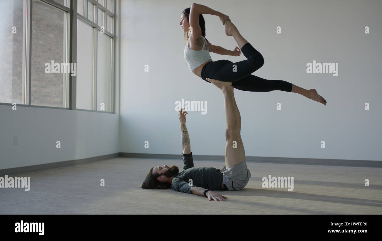 Heitere sportliche Tänzerin Holding Partner in der Luft auf Studioboden Stockfoto