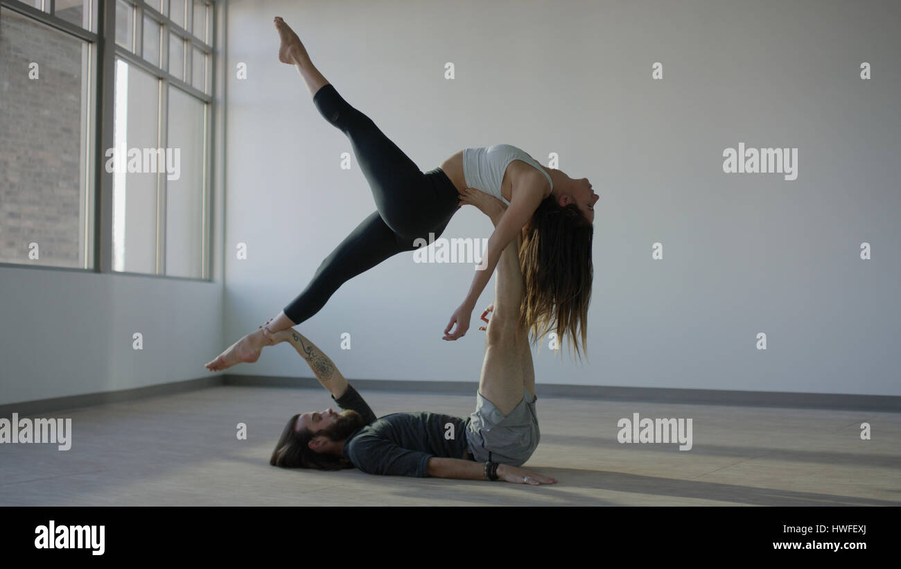 Heitere sportliche Tänzerin Holding Partner in der Luft auf Studioboden Stockfoto