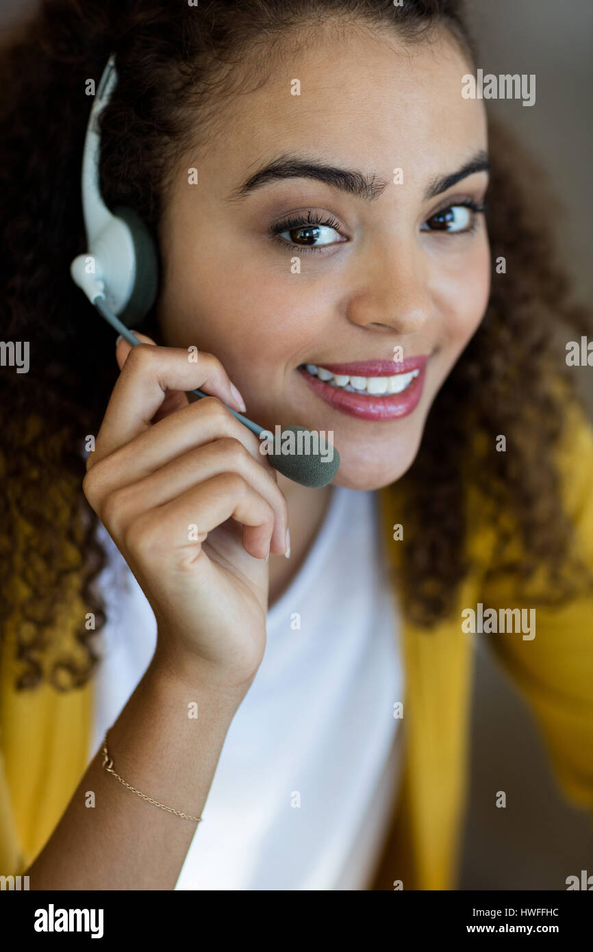 Lächelnde Kunden Service Executive Gespräch am Kopfhörer Stockfoto