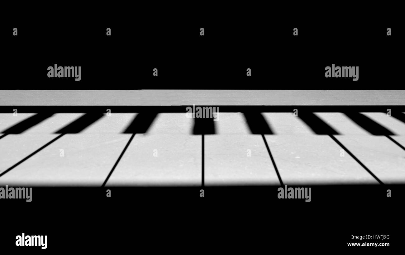 Piano-Tasten, die mit Schatten und Licht am Boden Stockfoto