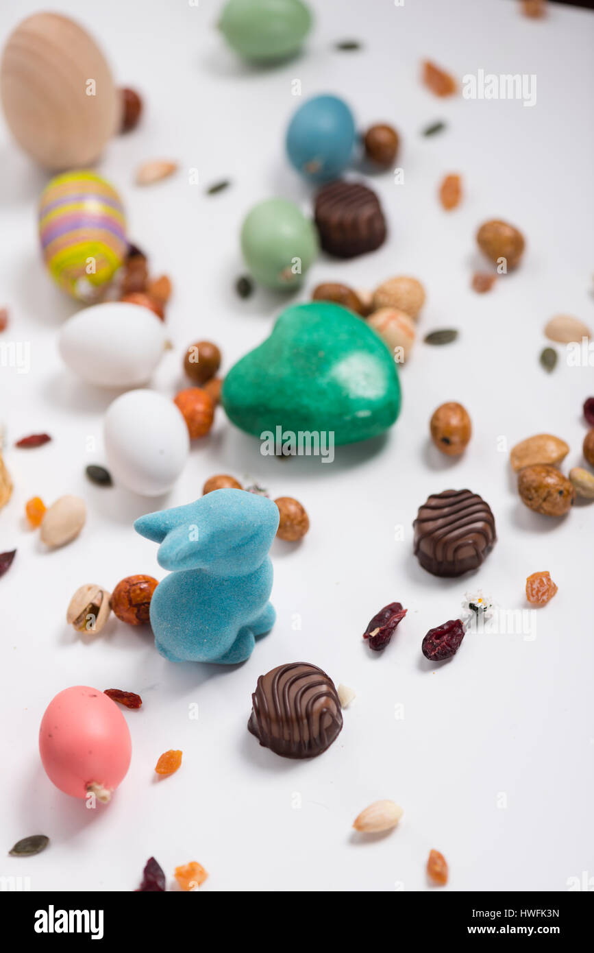 Osterhase, Konfetti, Eiern, Süßigkeiten, Samen, Pralinen und Requisiten Stockfoto