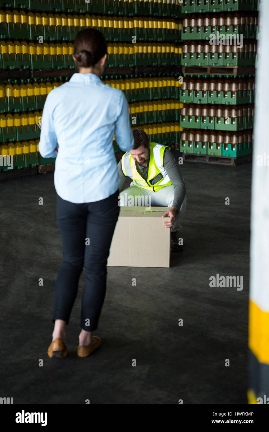 Rückansicht des weiblichen Manager betrachten männlichen Arbeitnehmer arbeiten im Lager Stockfoto