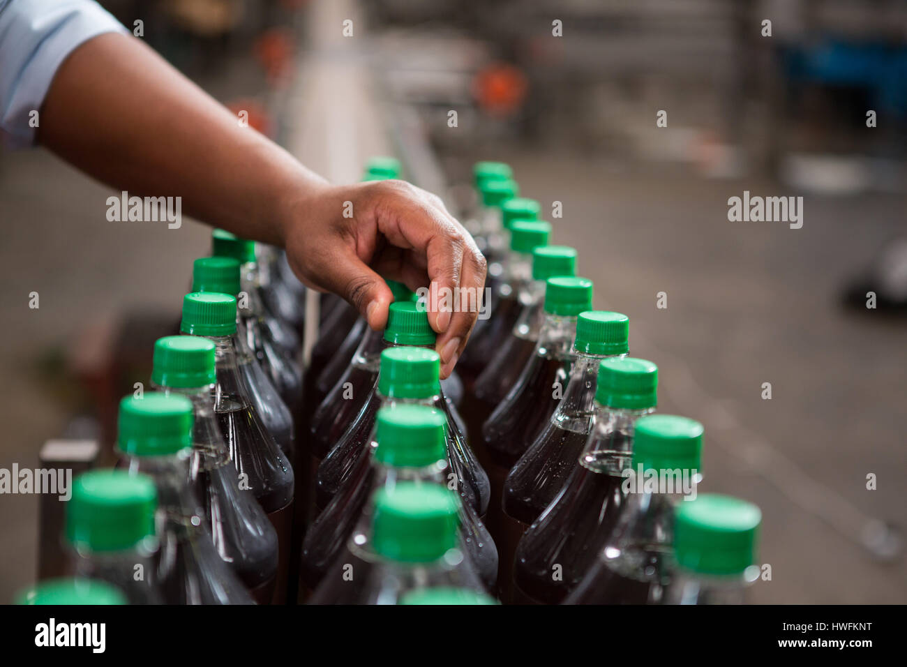 Hand der Arbeiter kontrollierenden Flaschen Saft Fabrik beschnitten Stockfoto