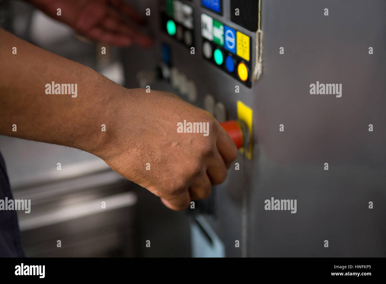 Hand der männlichen Arbeitnehmer bedienen von Maschinen im Werk abgeschnitten Stockfoto