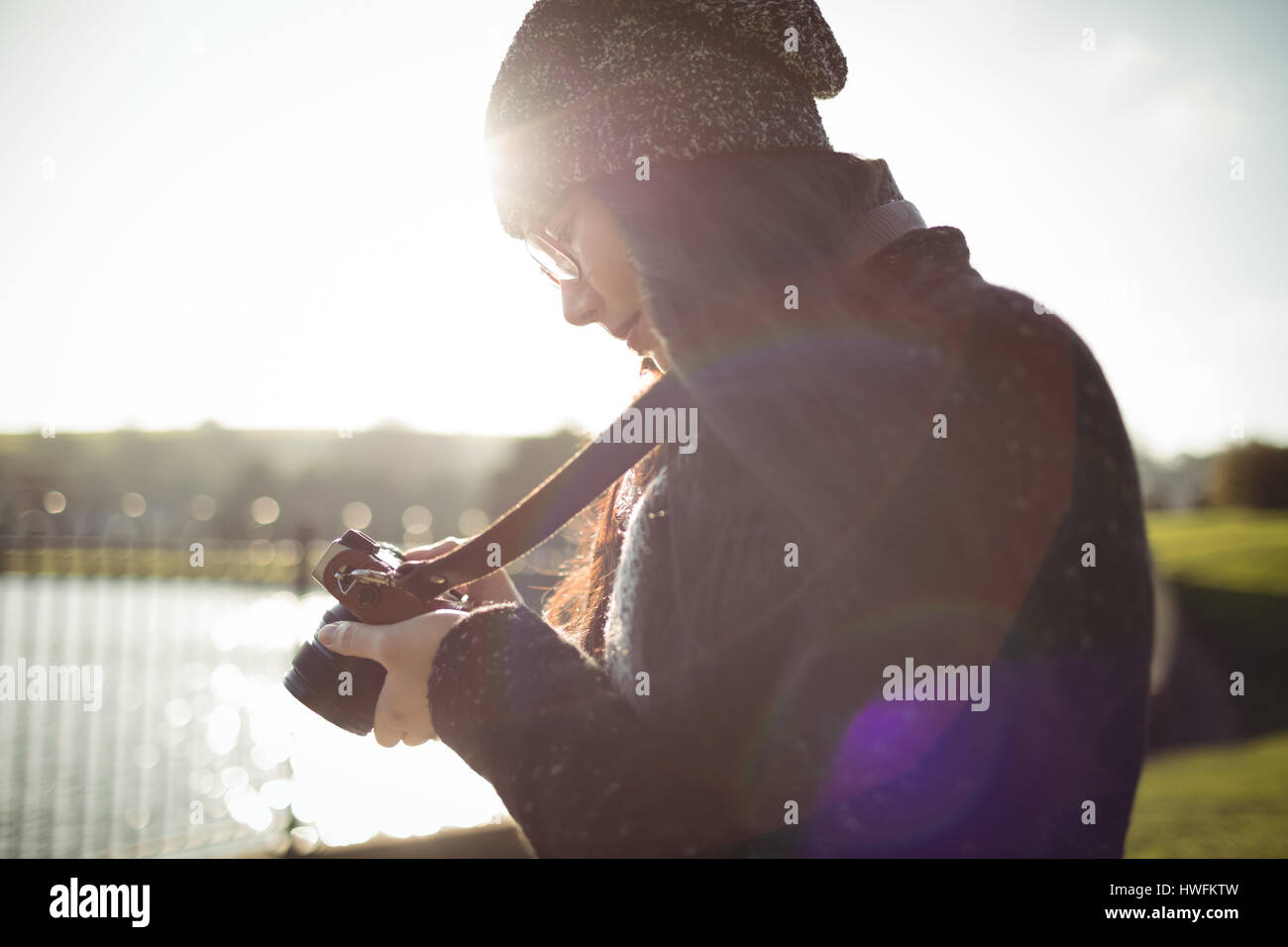 Frau mit Blick auf Fotos auf digitalen Kamera an einem sonnigen Tag Stockfoto