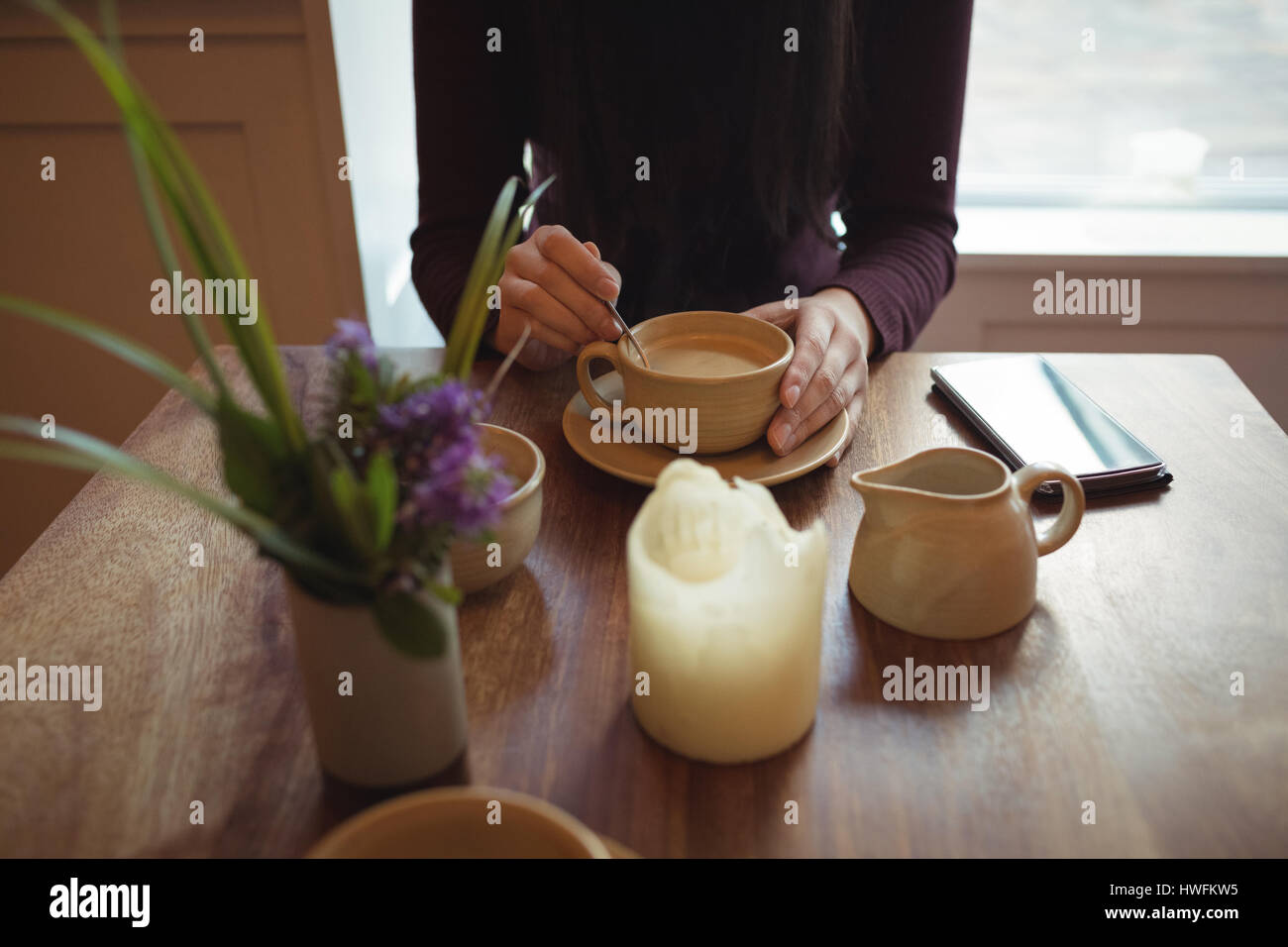 Mittelteil Frau rühren, Kaffee in der Tasse bei CafÃƒÂ © Stockfoto