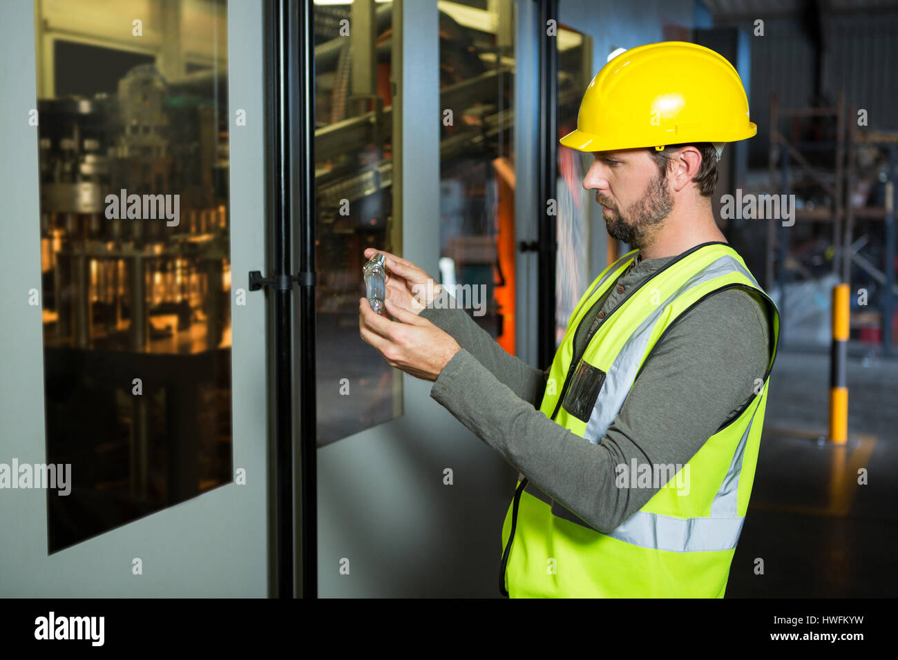 Seitenansicht der männlichen Arbeitnehmer Saft im Reagenzglas werkseitig geprüft Stockfoto