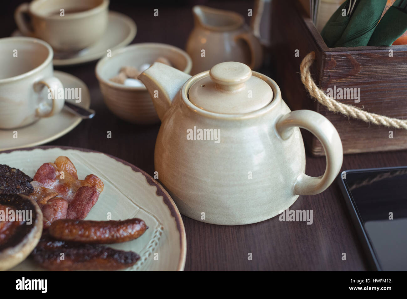 Nahaufnahme von Teekanne und Teller mit englisches Frühstück am Tisch in CafÃƒÂ © Stockfoto
