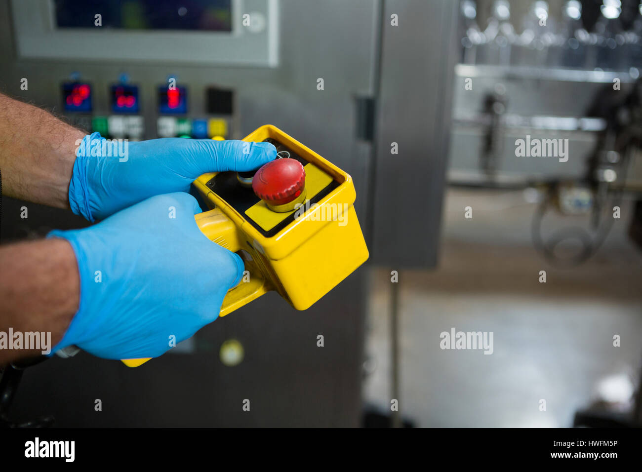 Hand des Arbeiters mit gelben Maschinen in der Fabrik zugeschnitten Stockfoto