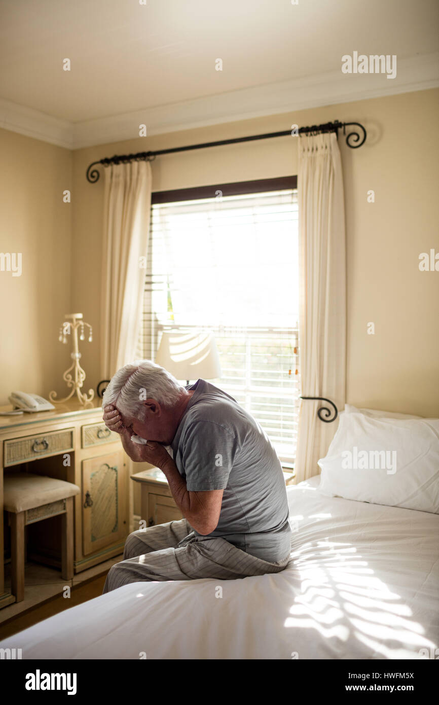 Älteren Mann mit einem Gewebe seine Nase in das Schlafzimmer zu Hause Blasen Stockfoto