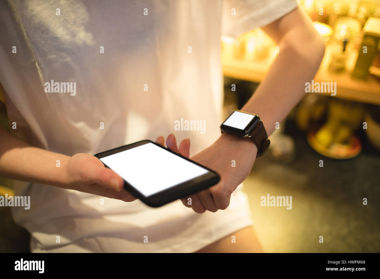 Mittleren Bereich der Frau mit Smartwatch Smartphone mit gedrückter Stockfoto