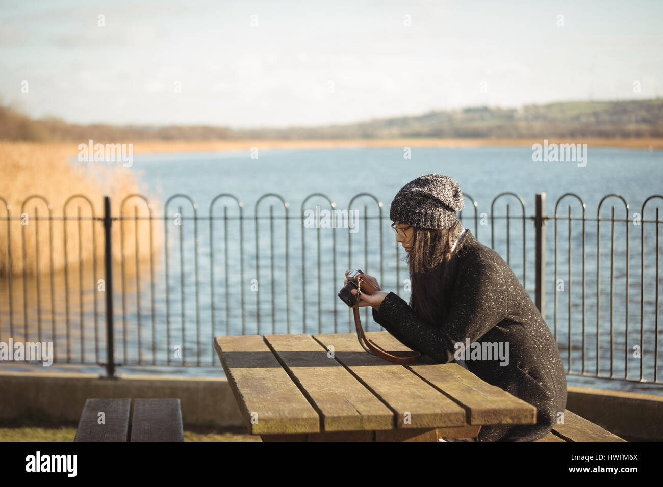Frau mit Blick auf Fotos auf digitalen Kamera an einem sonnigen Tag Stockfoto