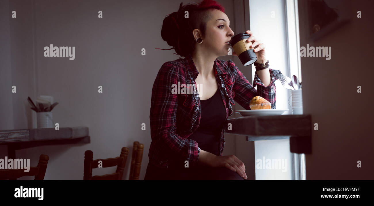Nachdenkliche Frau mit einer Tasse Kaffee in CafÃƒÂ © Stockfoto