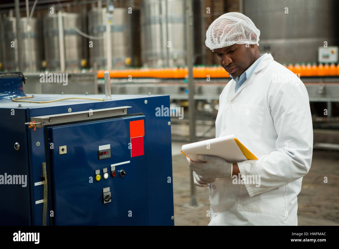 Schweren männlichen Arbeitnehmer Inspektion Maschinen werkseitig Saft Stockfoto