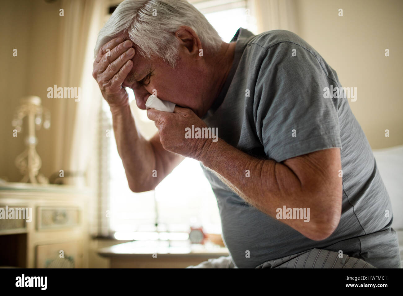 Älteren Mann mit einem Gewebe seine Nase in das Schlafzimmer zu Hause Blasen Stockfoto