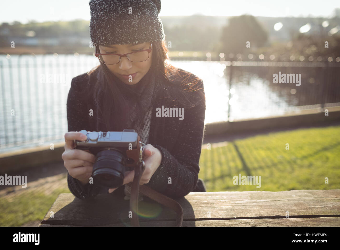 Frau mit Blick auf Fotos auf digitalen Kamera an einem sonnigen Tag Stockfoto