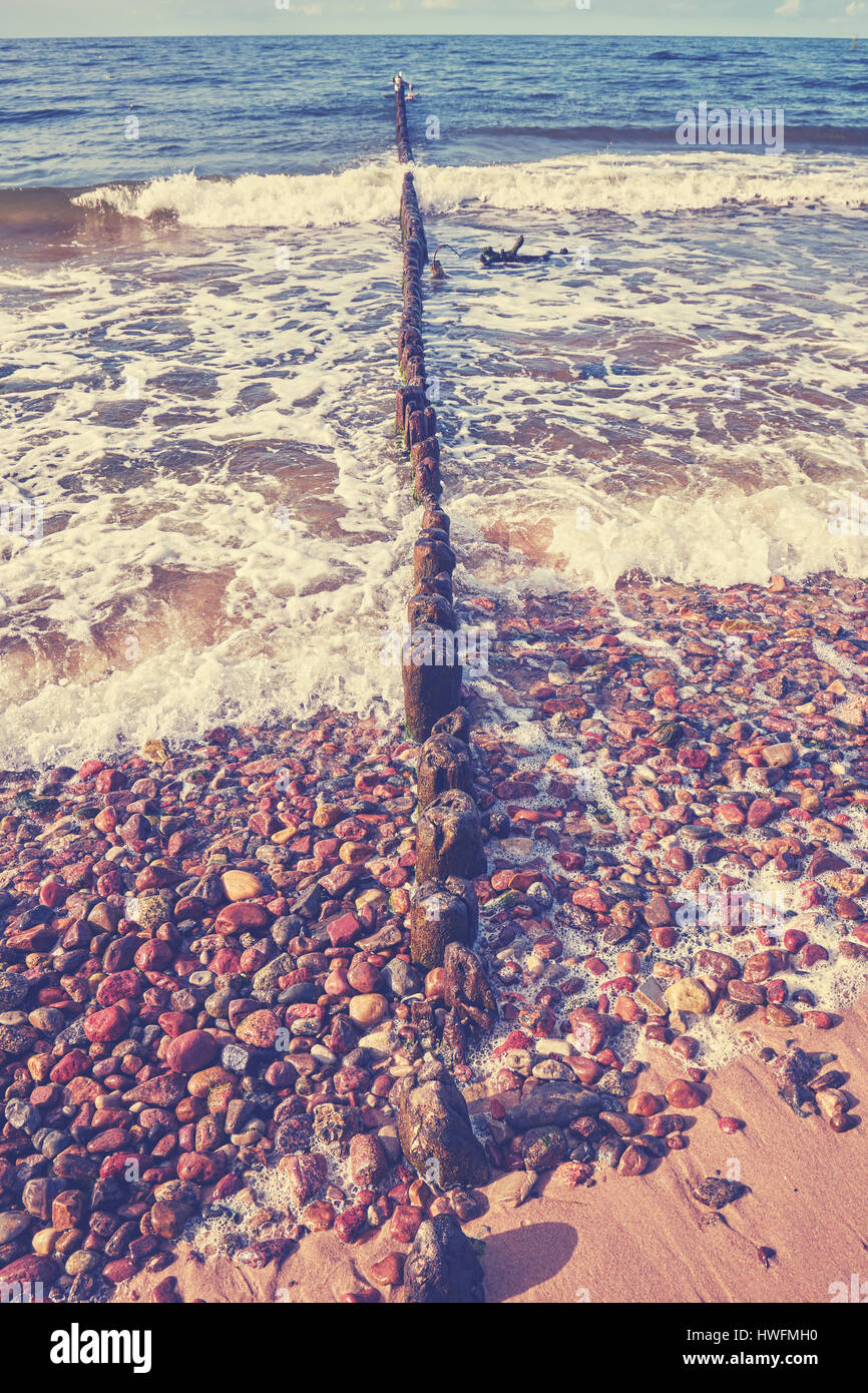 Alte hölzerne Wellenbrecher an einem Strand, Sommer Hintergrund angewendet Farbe toning. Stockfoto