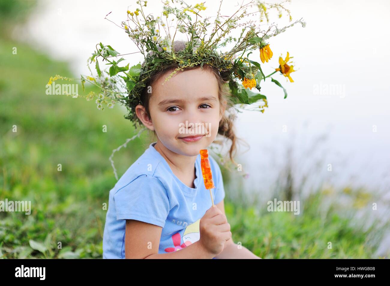 Babymädchen in einen Kranz von Wildblumen Stockfoto